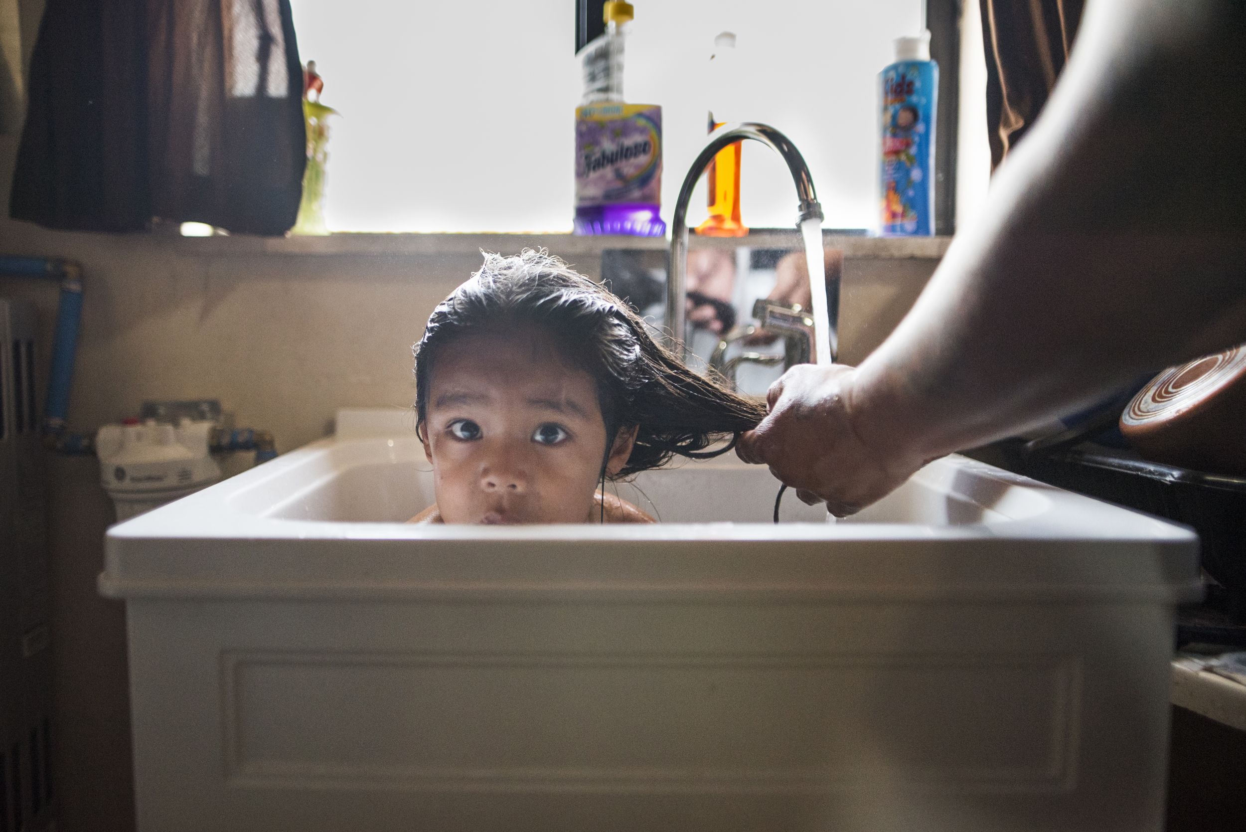 A child bathes in a sink in Navajo Nation. 