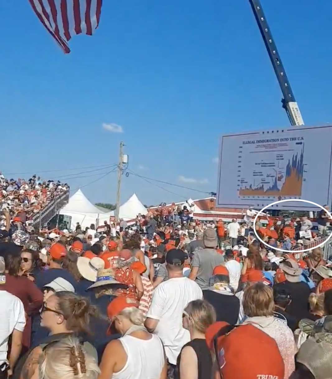 Screenshot of the crowd in the aftermath of the shooting at the Trump rally. On the right side of the image, a few people have their hands up and appear to be signaling for help.
